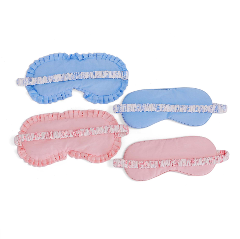ALT A set of four Toile print sleep masks in pink and blue, showing the printed front panel, solid backing, and elastic bands wrapped in matching Toile cotton fabric.