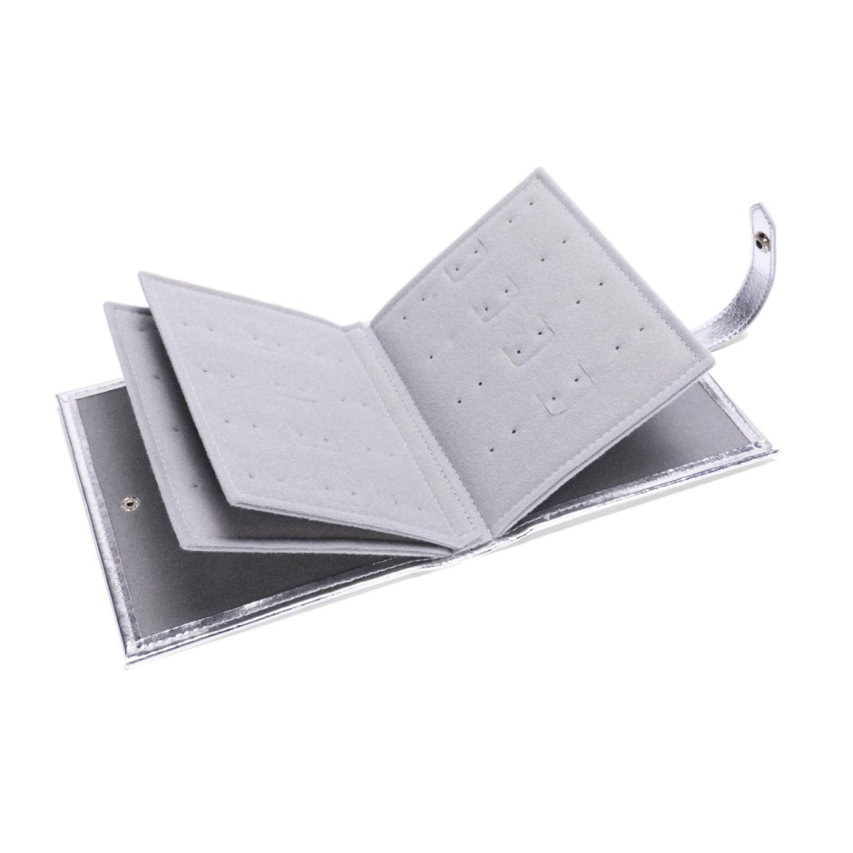 ALT A side angle of a silver foil earring organizer book opened to show the layered velvet insert pages with punched holes, with two pairs of pearl earrings attached to one page