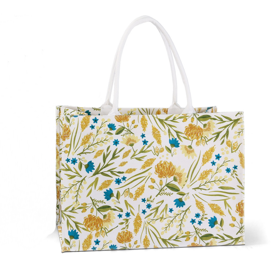 ALT Front view of a large yellow floral print canvas tote shopper bag with white webbing handles and a structured, upright shape.