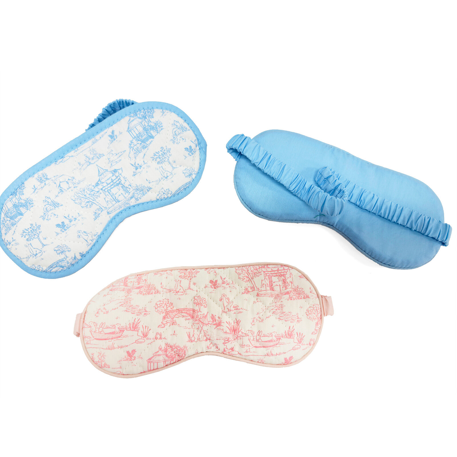 ALT Three organic cotton sleep masks with Toile prints, showing a pink piped style, a blue ruffle style, and a blue piped style with a matching fabric-wrapped elastic band